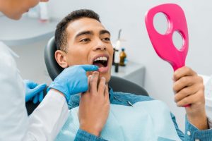 dentist showing patient's smile with a hand mirror